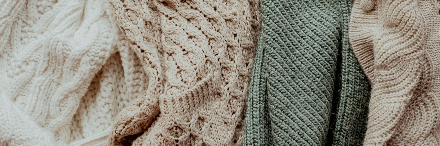 Close-up of soft knitwear in cream, oat and sage
